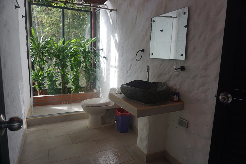 Covered jungle cabin lounge area surrounded by rainforest at Mahadevi Ayahuasca Retreat