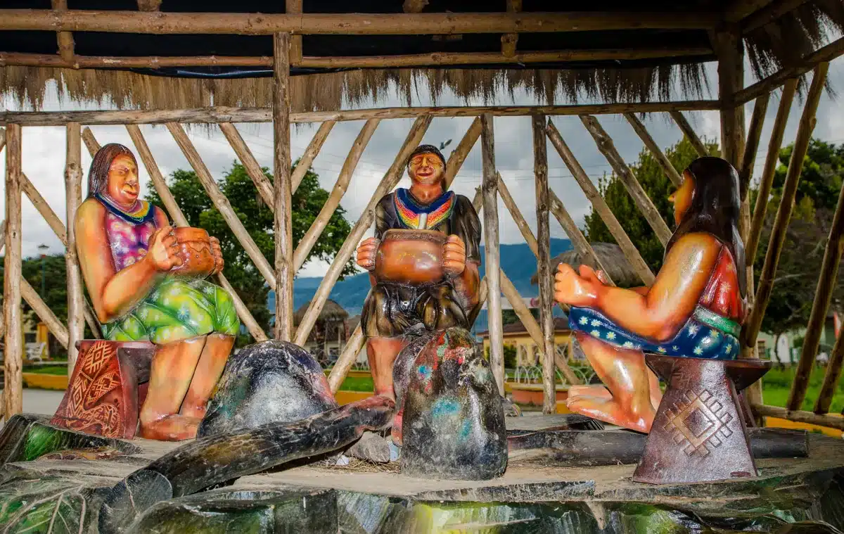 Maha Devi Ayahuasca | The Kamëntsá (Camsá) People and the Yagé Tradition of the Sibundoy Valley Painted sculpture in Sibundoy park depicting Kamëntsá people in traditional ponchos seated in a circle